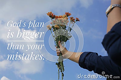 Inspirational word - God plan is bigger than your mistakes. Hand with flowers against bright and clean blue sky background. Stock Photo