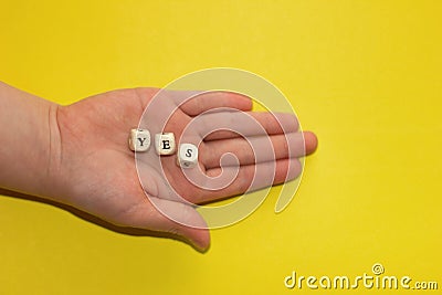 Inspirational word Yes on letter cubes in child& x27;s hand Stock Photo