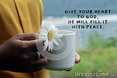 Inspirational words - Give your heart to God, He will fill it with peace. With woman holding coffee cup or tea cup and a flower. Stock Photo