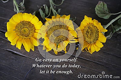 Inspirational words with yellow sun flowers - Go easy on yourself. Whatever you do today, let it be enough. Stock Photo