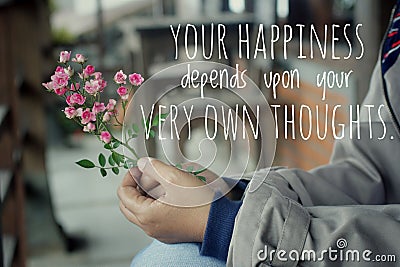 Inspirational words - Your happiness depends upon your very own thoughts. Hands holding pink little roses plant. Stock Photo