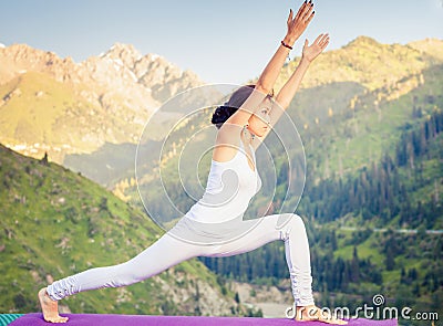 Inspired asian woman doing exercise of yoga at mountain range Stock Photo