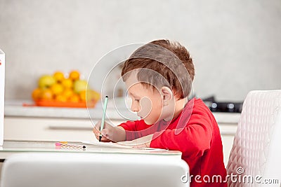 Inspired by the boy draws a picture on the paper at the table Stock Photo