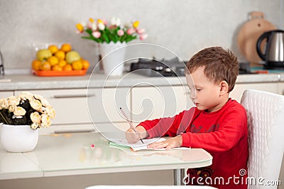 Inspired by the boy draws a picture on the paper at the table Stock Photo