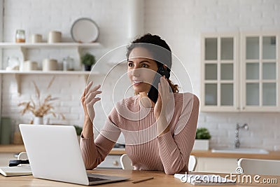 Inspired hispanic woman remote worker sitting by laptop making call Stock Photo