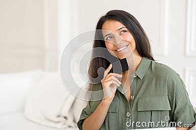 Inspired indian woman holding credit card and looks aside and dreaming Stock Photo