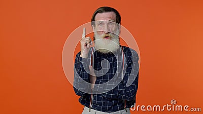 Inspired mature old bearded grandfather pointing finger up showing Eureka gesture, good idea Stock Photo