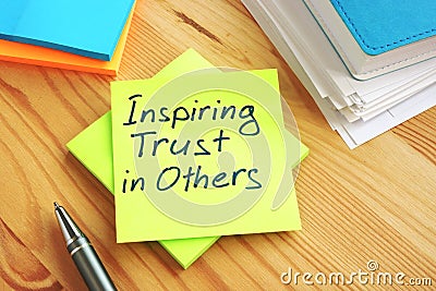 Inspiring Trust in Others written by hand on a page. Work in team concept Stock Photo