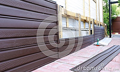 Installation of brown plastic siding on the facade Stock Photo