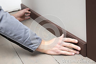 Installation of a brown wooden baseboard Stock Photo