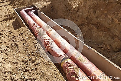 Installation of the distribution unit heating network. Frame for connecting pipes in the trench of ground. Stock Photo