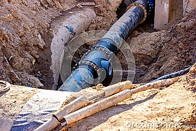 Installation of the distribution unit of heating and water supply network. Frame for connecting pipes in the trench of ground. Stock Photo