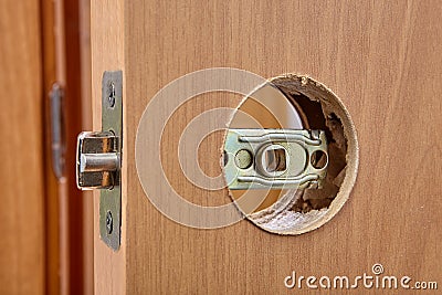 Latch assembly is inserted into door hole during installation. Stock Photo
