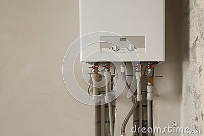 Installation of home gas heating boiler with red taps Stock Photo