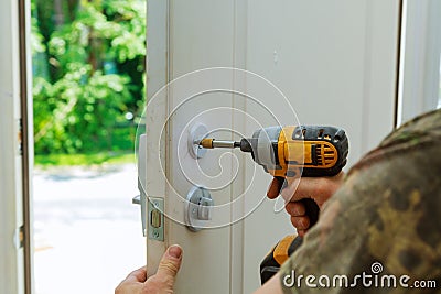 Installation locked interior door knobs, close-up woodworker hands install lock. Stock Photo