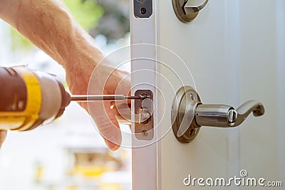 Installation locked interior door knobs, close-up woodworker hands install lock. Stock Photo