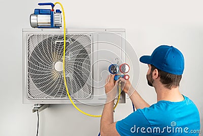 Installation service fix repair maintenance of an air conditioner outdoor unit, by cryogenist technican worker evacuate the Stock Photo