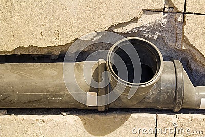 Installation of sewer pipes in a bathroom of an apartment interior during renovation works. Gray plastic drain pipe for used water Stock Photo