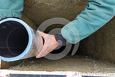 Installation of a ventilation pipe in the chimney, the pipe is wrapped with foil for cooling Stock Photo