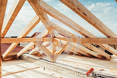 Installation of wooden beams at house construction site. Building details with wood, timber and iron holders Stock Photo