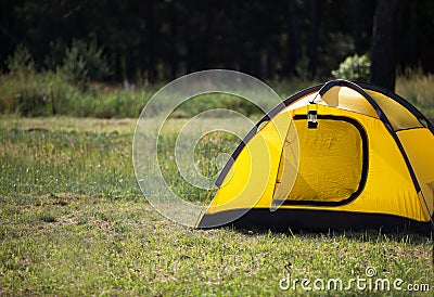 Installed tourist tent and a camping lantern in nature in the forest. Domestic tourism, active summer holidays, family adventures Stock Photo