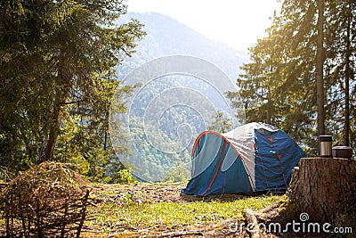 Installed tourist tent in a camping in nature in the forest. Domestic tourism, active summer holidays, family adventures. Stock Photo