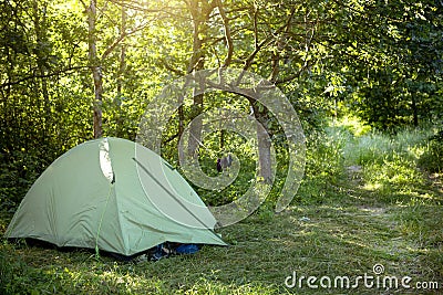 Installed tourist tent in a camping in nature in the forest. Domestic tourism, active summer holidays, family adventures. Stock Photo