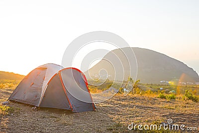 Installed tourist tent in the mountains with a view of the sea and sunrise. Domestic tourism, active summer trip, family Stock Photo