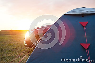 Installed tourist tent near the car. Domestic tourism, active summer trip, family adventures, auto camping. Ecotourism. Travel by Stock Photo