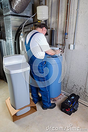 Installer inputting settings on a water softener Stock Photo