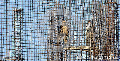 Installers against the blue sky collect metal structures Editorial Stock Photo