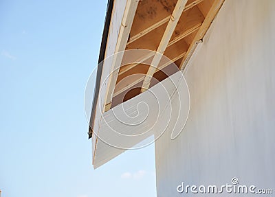 Installig eaves, soffit boards, fascias on new house roofing construction Stock Photo