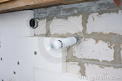 Installing anchors in house wall for rigid insulation foam in smoke pipe problem area Stock Photo