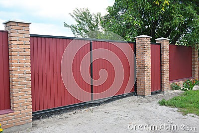 Installing Brick and Metal Fence Gate with Door. Red Metal Fencing Panels. Stock Photo