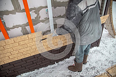 Installing brick siding on the wall of the house Stock Photo