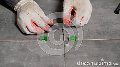 Installing a fixture for off-floor ceramic tiles. Fasteners for laid tiles. Laying ceramic tiles on a concrete floor. Stock Photo