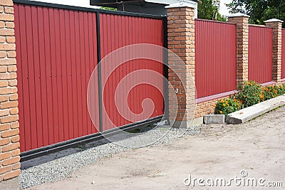 Installing house red metal fence with garage gate of modern style design Stock Photo