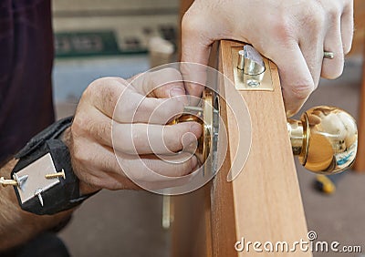 Installing interior door, carpenter installs knob using magnetic Stock Photo