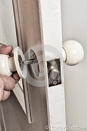 Installing the latch on the door. Stock Photo