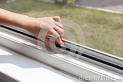 Installing mosquito nets for plastic windows. Stock Photo