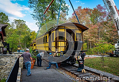 Installing a New Yellow Passenger Antique Coach Being Lifted By a Crane Editorial Stock Photo