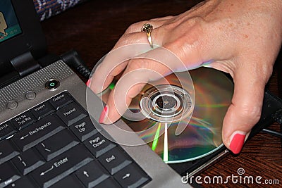 Installing program from DVD to laptop computer - Image Stock Photo
