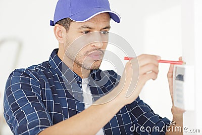 Installing programmable room thermostat Stock Photo