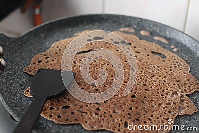 Instant Finger Millet Dosa, made with finger millet flour, curd and spices. Cooked on a saute pan or hot skillet for a few minutes Stock Photo