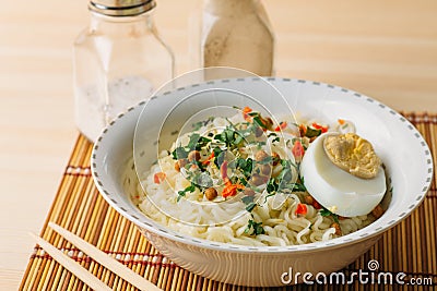 Instant noodles in bowl, Asian fast food on wooden table Stock Photo