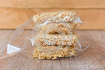 Instant noodles in package on wooden background - dry food non perishable storage goods in kitchen home or for donations Stock Photo