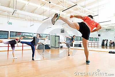Instructor And Clients Kickboxing In Dance Class At Gym Stock Photo