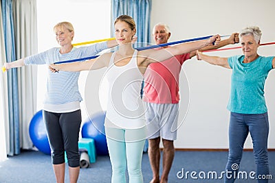 Instructor and seniors exercising with stretching bands Stock Photo