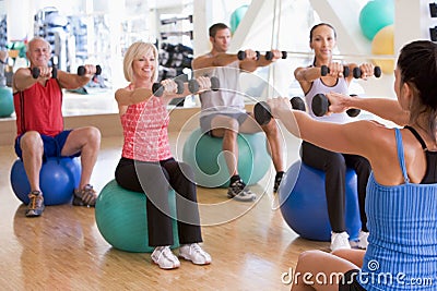 Instructor Taking Exercise Class At Gym Stock Photo