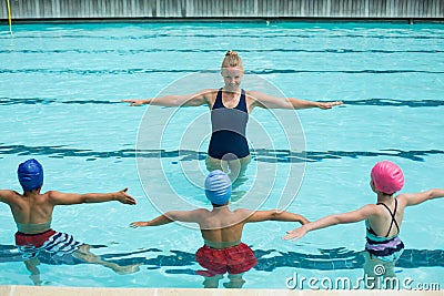 Instructor teaching students in swimming pool Stock Photo